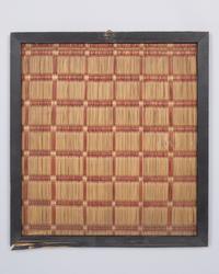 Sample of goods  
raffia, wood  
38,5 × 35,5 cm  
Geographical classification: China  
DM VI 79
Object description  
Piece of a woven mat set in wood; lattice pattern in red and nature.
Provenance  
Kunstmuseen Krefeld (since 1923); Deutsches Museum für Kunst in Handel und Gewerbe (until 1923); Rex & Co. (until 1913); transfer to Germany (unknown); manufacture
(unknown).
Object history  
The woven mat piece was purchased for the DM's wickerwork exhibition in June 1913 through Rex & Co. in Berlin, a store specializing in the import of "Japan, China and Oriental goods." A total of 12 mat samples were ordered for the exhibition, six of which are still extant.  
Hagen-born patron of the arts Karl Ernst Osthaus founded the Deutsches Museum für Kunst in Handel und Gewerbe in 1909 with the support of the Deutscher Werkbund. With the museum, Osthaus pursued the goal of creating an aesthetic imprint on industrial product design by investing in and lending out exemplary arts and crafts. To this end, the museum lent traveling exhibitions to interested institutions in German-speaking countries and beyond. In 1911, an exhibition on "exotic wickerwork", which was also promoted as "examples of good craftsmanship", was added to the program.