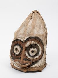 Mask  
Beef bast, painted  
34 × 26 cm  
Geographical allocation: Papua New Guinea  
ZV 2000/704
Object description  
A cane mask with bark bast overlay; face partly preformed and painted from attached rotan struts; mask colored in white, light brown and dark brown.
Provenance  
Verein deutscher Seidenwebereien Krefeld (until unknown); J.F.G. Umlauff (until 1928); transfer to Germany (unknown); appropriation in region of origin (unknown); manufacture (unknown).
Object history  
In July 1928, the "Verein der deutschen Seidenwebereien, Krefeld" (Association of German Silk Weavers, Krefeld) purchased a total of ten objects from various regions of the Pacific islands from the Hamburg-based company J.F.G. Umlauff, which specialized in the sale of ethnographic objects. The purchase was made in the wake of the exhibition "Color", which was on display at the Kaiser Wilhelm Museum from May 1 to 31, 1928.  
Presumably it is an eharo mask. These were part of the hevehe mask cycle of the Elema society living in the eastern Papuagolf region. Unlike the larger hevehe masks, which were considered sacred and whose production took place in secret, the eharo masks served to entertain and amuse the public at the beginning and end of the mask cycle. The shape and design of the masks, which could represent different beings, figures and characters, varied greatly. Since the 1950s, the hevehe cycle is no longer practiced.