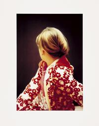 Gerhard Richter  
Betty, 1991  
Offsetdruck, 4-farbig, auf Karton, mit Nitrolack beschichtet, 97,1 × 66,2 cm  
Erworben 1997  
FK 50  
© der Künstler  
Foto: Kunstmuseen Krefeld / Volker Döhne
<span style="color: #2f7176;">Ein Porträt, das keines ist, zumindest im klassischen Sinne.
Eine Person (Betty), die man anhand ihrer Kleidung, Statur und Frisur wiedererkennen könnte. Besonders denjenigen, die sie kennen, mag sie vertraut erscheinen, aber es bleibt eine Unsicherheit trotz des auffallenden Kleidungsstücks und der Linie der Kinnpartie.  
Jedes Detail ist erkennbar, jede Haarsträhne, jede Blüte auf dem Jackett.  
Der Blick zurück oder in die Ferne scheint ungeplant. Als ob im Moment der Aufnahme außerhalb des Bildes hinter dem Motiv etwas plötzlich und überraschend stattfindet, welches das geplante Arrangement in dem Moment stört, als der Fotograf auf den Auslöser gedrückt hat.  
Es hat ein wenig gedauert, bis ich dieses Bild als das überraschendste in der Sammlung für mich ausgewählt habe, da mir das Sujet zunächst zu belanglos erschien. Zumal in der Sammlung jede Menge Mobiliar und angewandte Kunst vorhanden sind, die mir persönlich näher liegen könnten.
Christoph Tölke</span>
